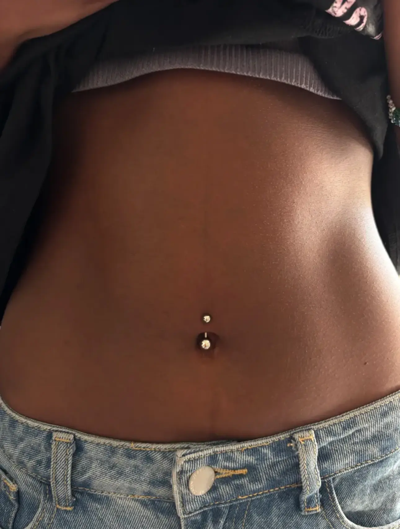 Fresh gold navel piercing with gem ends